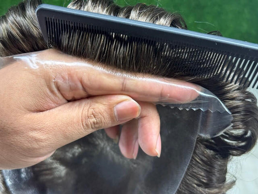 Prótese Capilar Masculina being styled with a comb, showcasing natural hair texture and versatility.