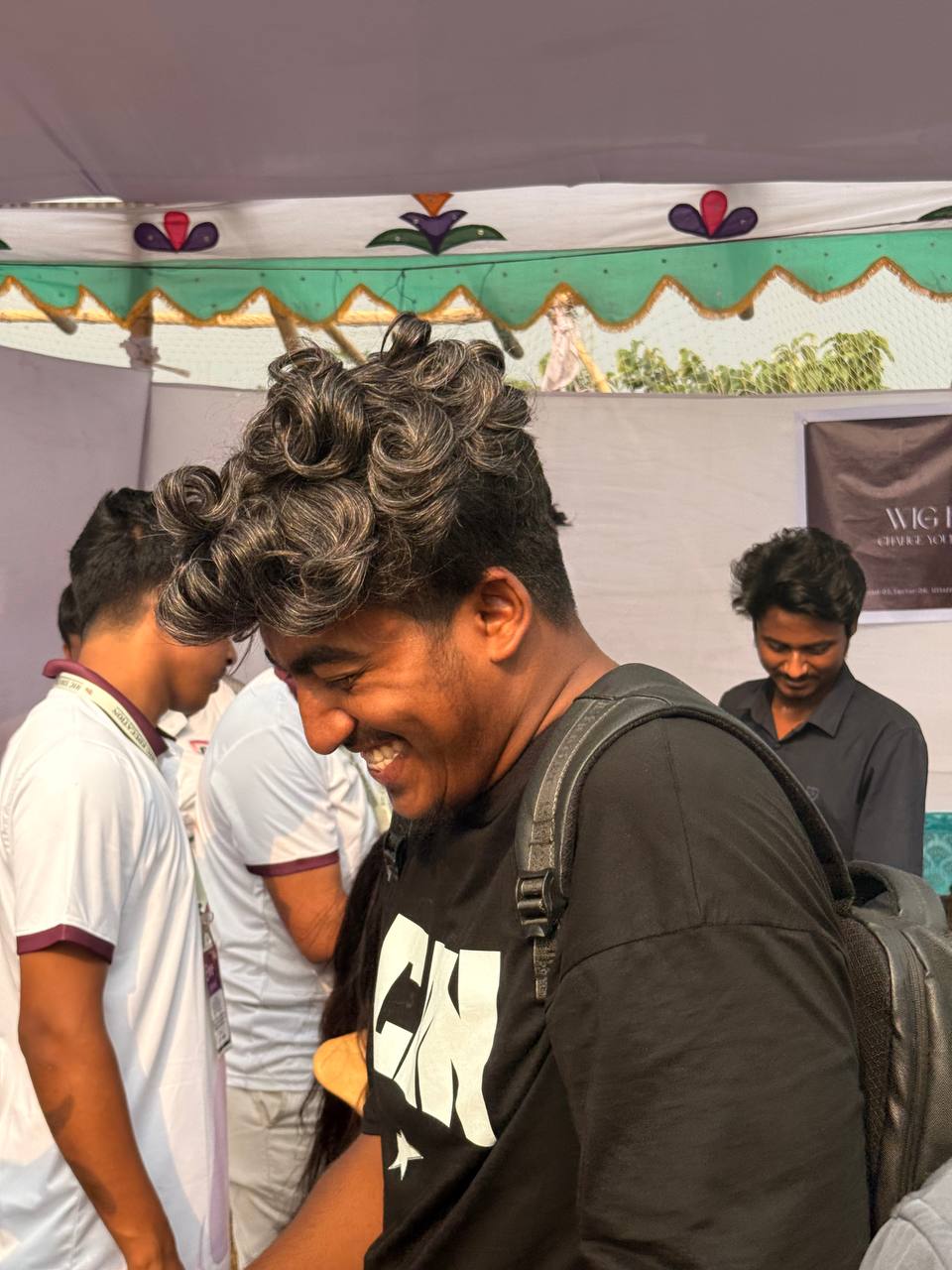 Smiling student wearing a styled hair system at the event