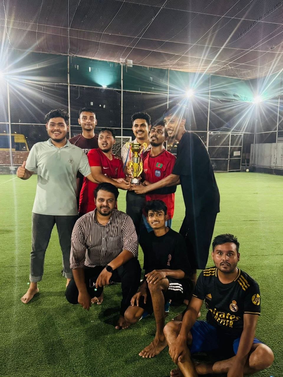 Employee football team celebrating with a trophy
