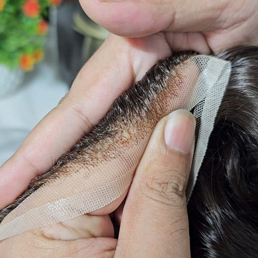 Close-up of hands examining SP Mono Hair System for premium men's toupee system quality and features.